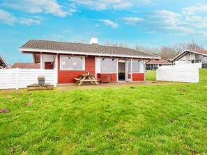 A red and white building with a covered patio area and a picnic table. - 4 Star Holiday Home in Aabenraa (Aabenraa)