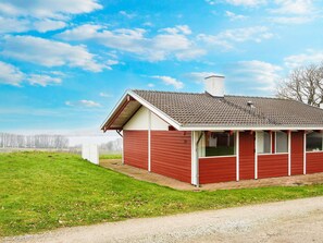 A single-story house with a red exterior, a chimney, and a small porch. - 4 Star Holiday Home in Aabenraa (Aabenraa)
