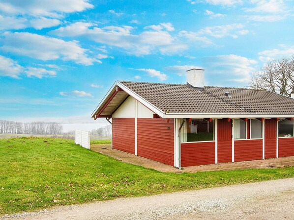 A single-story house with a red exterior, a chimney, and a small porch. - 4 Star Holiday Home in Aabenraa (Aabenraa)