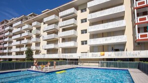 A multi-story hotel with balconies, a swimming pool, and a fenced deck area. - Holiday Home Near Spiaggia Tartaruga (Caorle)