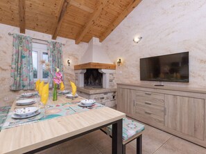 Enjoy dining and socializing in this inviting space with a fireplace, flat-screen TV, and beautifully set table.