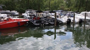 A marina with several boats docked, including a red boat with "15 PS" and a white boat with "LAX" on its side. - Holiday Room Lenzer Hafen (Fuenfseen)