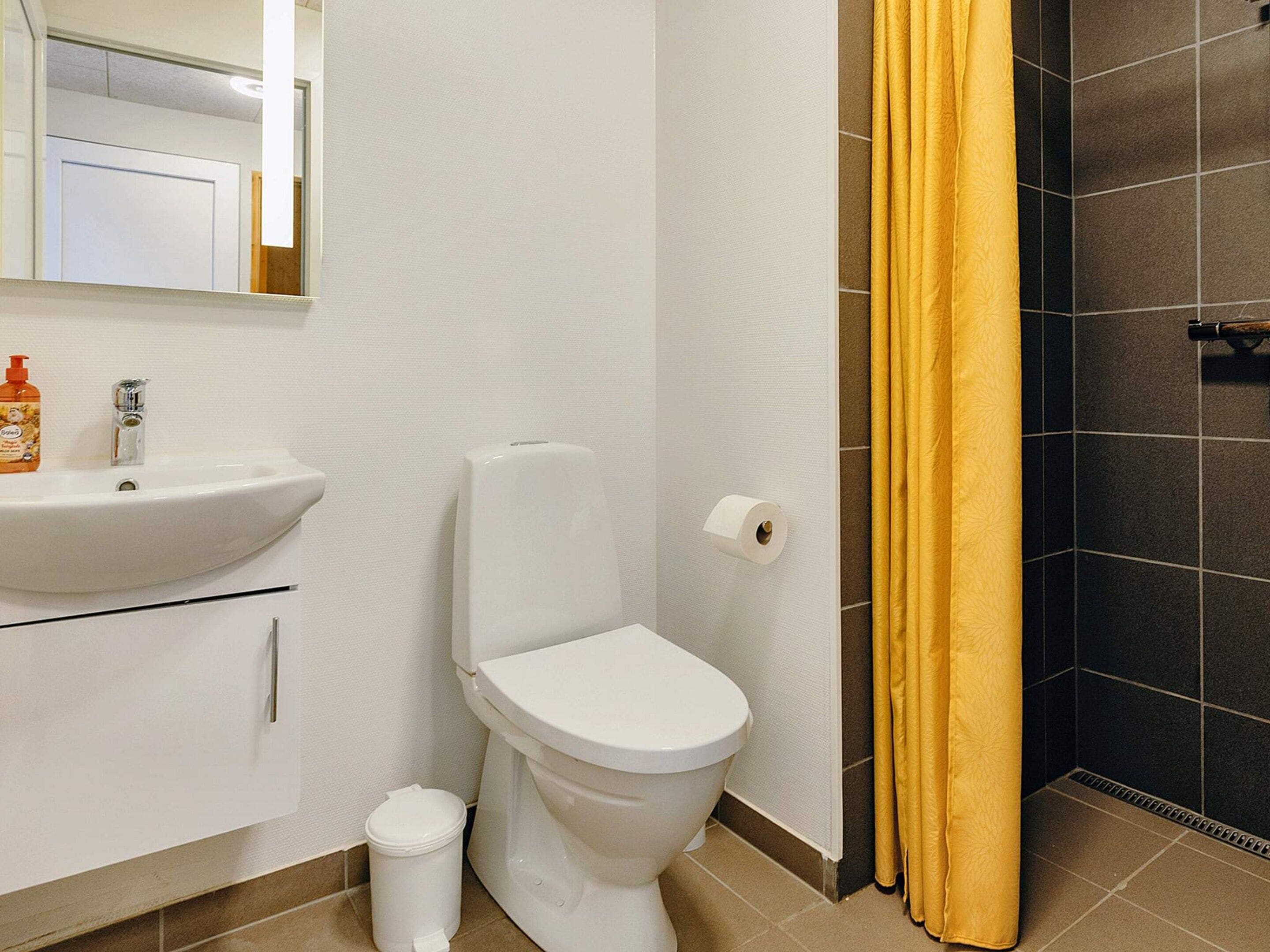 Ein Badezimmer mit Waschbecken, Toilette und Duschvorhang.