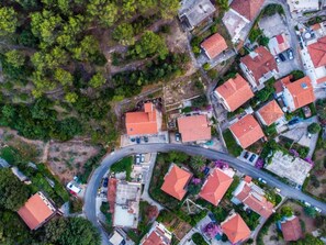 An aerial view of a residential area with houses, a winding road, and surrounding greenery. - Apartments St Rialto - Comfort One-bedroom Apartment With Balcony (Jelsa)