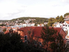 A town with red-roofed buildings, surrounded by greenery and hills. - Apartments St Rialto - Comfort One-bedroom Apartment With Balcony (Jelsa)
