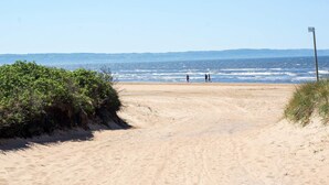A sandy beach path leading to the sea with a few people walking. - 5 Person Holiday Home in Skummeslovsstrand (Skummesloevsstrand)