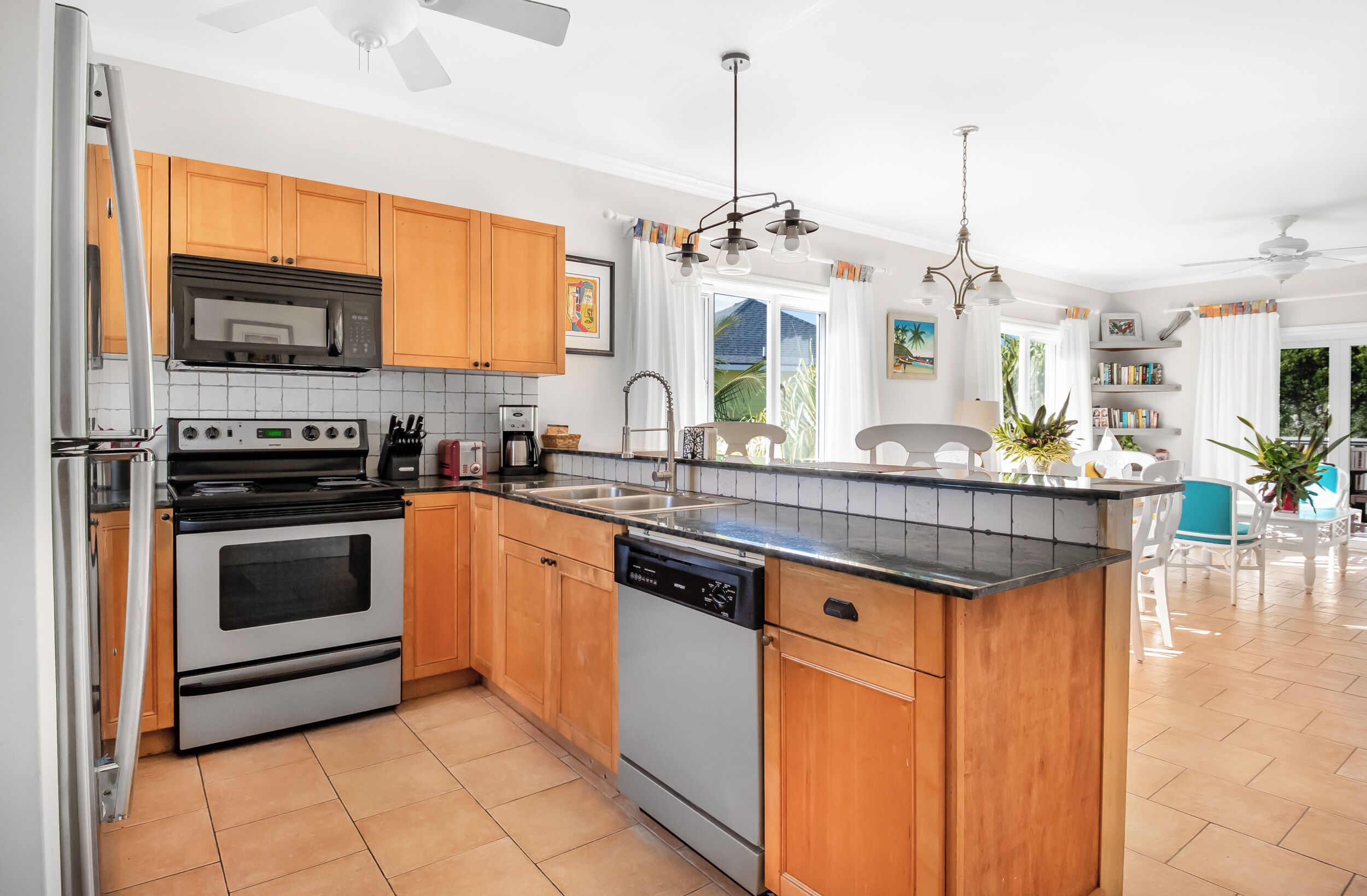 A modern kitchen with wooden cabinets, stainless steel appliances, and a large island.