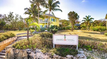 A yellow building with a sign for Pineapple Fields Eleuthera Bahamas.