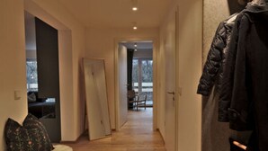 Un couloir doté d’un plancher en bois, d’un banc recouvert de fourrure et d’un porte-manteau.