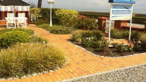 A pathway leading to a building with a sign labeled "Apartments". - 2 Rena Modern Retreat (Sierksdorf)
