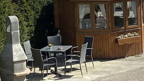 A wooden gazebo with a table and chairs, overlooking a body of water. - 2 Rena Modern Retreat (Sierksdorf)