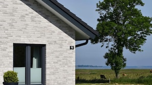 Un bâtiment moderne avec une façade en briques blanches, une grande fenêtre et un panneau indiquant le numéro « 9 ».