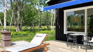A wooden deck with a lounge chair, a small table, and chairs. - 4 Star Holiday Home in Lottorp (Löttorp)