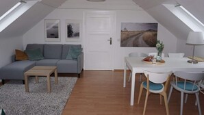 A modern loft bedroom with a sloped ceiling, a large window, a bed, a bedside table, and a wardrobe. - Holiday Home "schwedenhaus Bad Tabarz" (Tabarz)