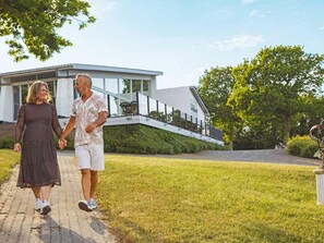 A modern house with a glass facade, a paved driveway, and a grassy lawn. - 1 Person Holiday Home in Allinge (Allinge)