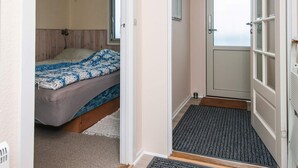 A bedroom with a bed, a window, and a door leading to a balcony. - 4 Person Holiday Home in Fano (Fano)