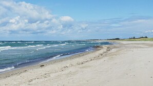 Ein Strand mit sandigem Ufer und Wellen.