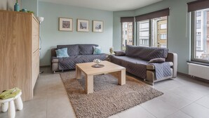A modern living room with two sofas, a coffee table, and a wooden cabinet. - Pleasant Apartment Near the Seafront (Blankenberge)