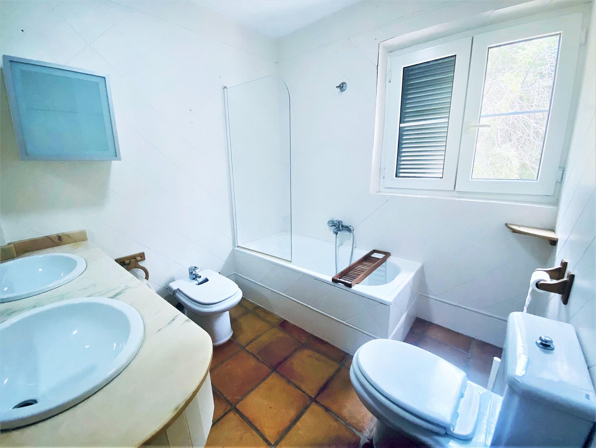 Une salle de bain avec deux lavabos, des toilettes, une baignoire et une douche.
