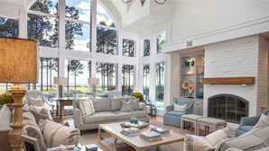 A spacious living room with a fireplace, large windows, and a view of the outdoors. - 21 Painted Bunting at The Sea Pines Resort (Hilton Head Island)
