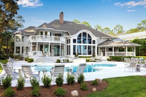Une grande maison dotée d’une piscine, de plusieurs terrasses et d’espaces aménagés pour se détendre à l’extérieur.