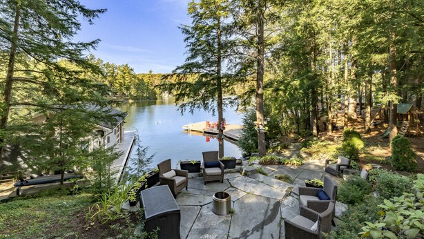 A lakeside patio with outdoor furniture, a dock, and a playground. - 7 bed, 5 bath spectacular cottage on Lake Joseph! (Parry Sound Mid-Shore (Bala))
