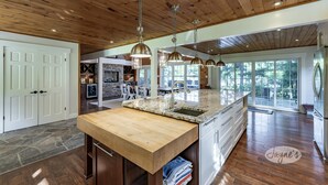 A spacious kitchen with a wooden ceiling, granite countertops, and pendant lighting. - 7 bed, 5 bath spectacular cottage on Lake Joseph! (Parry Sound Mid-Shore (Bala))