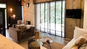 Una sala de estar moderna con una pared de madera, un sofá, una mesa de centro y un televisor.