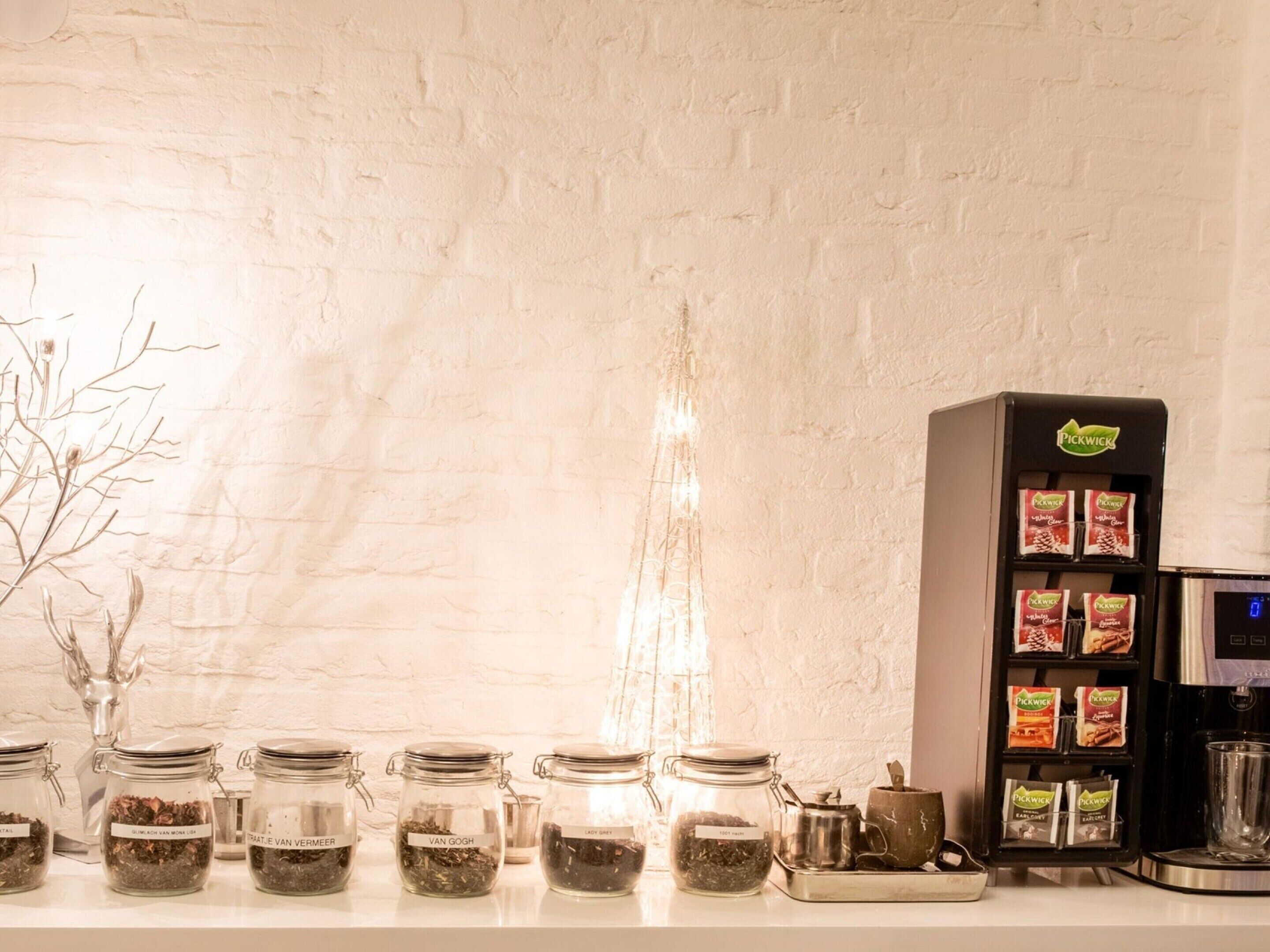 Eine Kaffeestation mit einer Kaffeemaschine und beschrifteten Gläsern mit verschiedenen Kaffeemischungen.