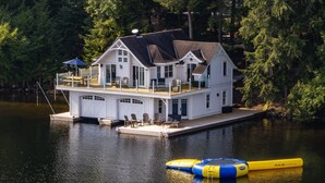 Ein Haus am Wasser mit Anlegesteg, Sitzgelegenheit im Freien und einem Kajak.
