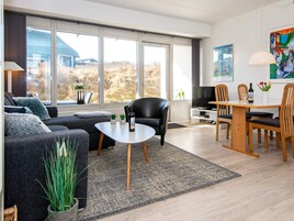 Una sala de estar moderna con un sofá, una mesa de centro y una zona de comedor.