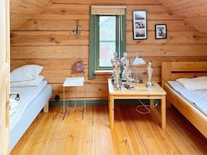 A cozy cabin room with two beds, a small table with trophies, a lamp, and a window with a view. - 4 Star Holiday Home in Yngsjo (Yngsjo)