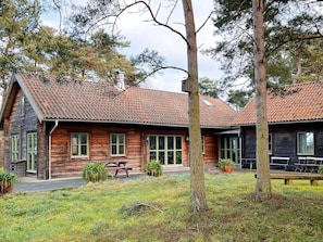 A rustic wooden cabin with a tiled roof, a front porch, and a bench. - 4 Star Holiday Home in Yngsjo (Yngsjo)