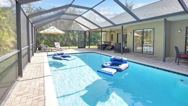 Ein überdachter Pool mit Liegestühlen und einer Sonnenterrasse.