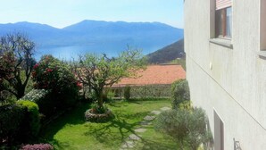 Vista de una casa con jardín y una montaña al fondo.