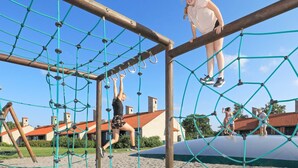 Un parque infantil con una estructura de red y vigas de madera.