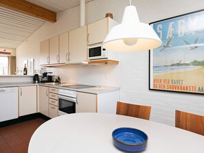A modern kitchen with white cabinets, a microwave, and a large pendant light. - 6 Person Holiday Park Home in Saeby (Sæby)