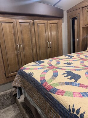Una camera da letto con un letto grande, un armadio in legno e una porta.