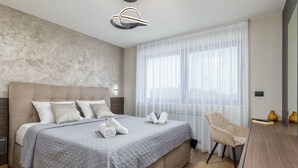 Una camera d'albergo moderna con un letto grande, una scrivania e una sedia.