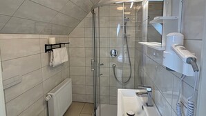 A modern bathroom with a glass-enclosed shower, a white sink, and a toilet. - Gap Hotel Event & more  (Langwedel)