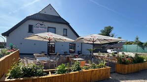 A hotel named Gap Hotel with outdoor seating and planters. - Gap Hotel Event & more  (Langwedel)