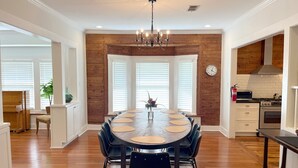 A dining area with a round table, black chairs, and a chandelier. - Historic 7-BR Luxury with hot tub, in the heart of town (San Antonio)