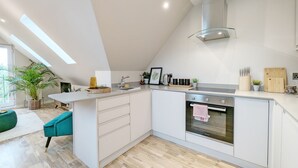 Una cocina moderna con una isla central, horno integrado y tragaluz.