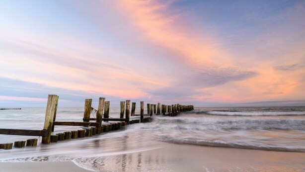 A beach with a wooden jetty extending into the ocean. - Message in a Bottle Modern Retreat (Zingst)