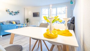 A modern living room with a white table, blue sofa, and yellow accents. - Message in a Bottle Modern Retreat (Zingst)