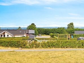 A residential area with houses, a playground, and a clear view of the sea. - 5 Star Holiday Home in Bogense (Bogense)