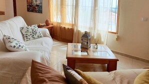A living room with a white sofa, a glass coffee table, and a painting on the wall. - Villa Fiorida Comfortable Holiday Residence (Calpe)