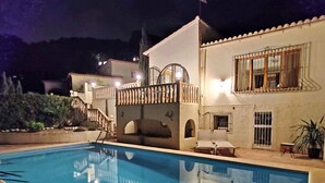 A swimming pool with a sunken seating area, a staircase leading to a balcony, and a potted plant near the pool. - Villa Fiorida Comfortable Holiday Residence (Calpe)