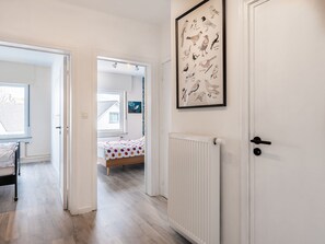 A bedroom with a bed, a radiator, and a door. - Nice Apartment in Koksijde With Balcony (Koksijde)