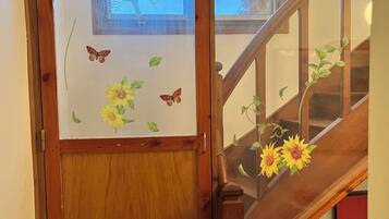 A wooden staircase with a glass door featuring a butterfly and sunflower decal.
